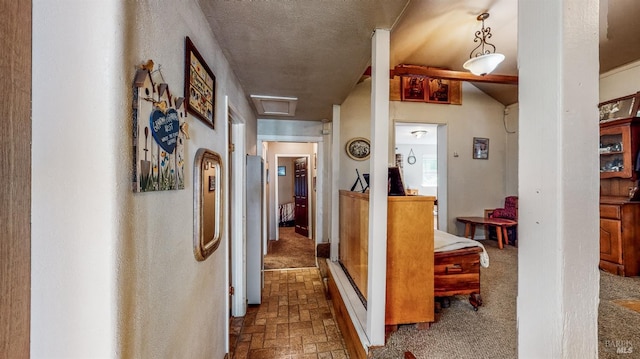 hall featuring a textured ceiling and carpet floors