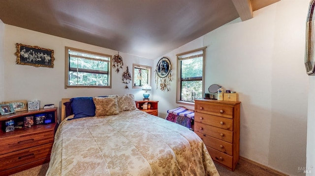 carpeted bedroom featuring lofted ceiling with beams