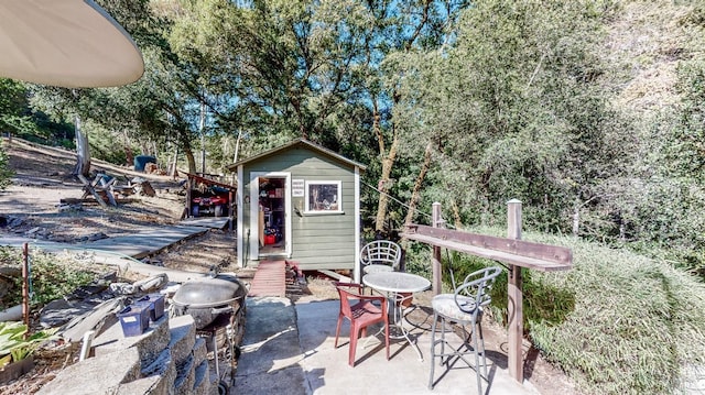 view of patio featuring an outbuilding and a storage unit