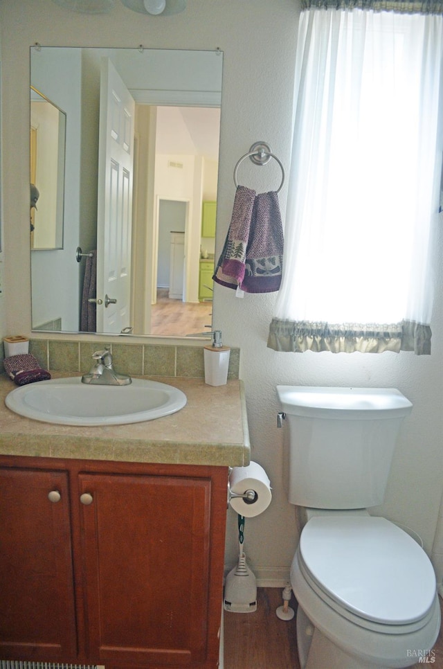 bathroom featuring wood-type flooring, vanity, and toilet