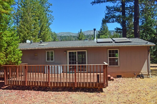 rear view of house with a deck with mountain view