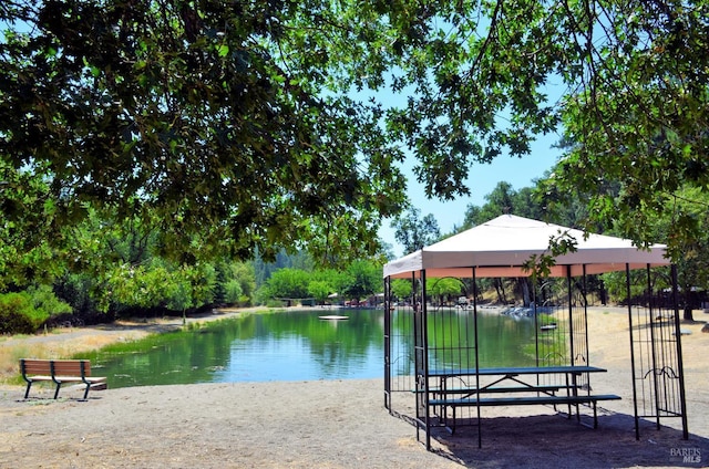 surrounding community with a gazebo and a water view