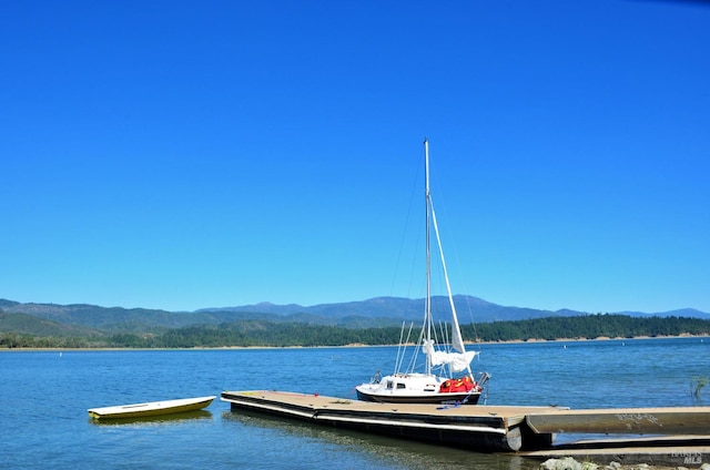 view of dock with a water and mountain view