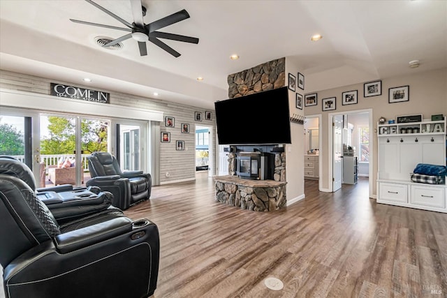 living room featuring ceiling fan, hardwood / wood-style flooring, and a fireplace