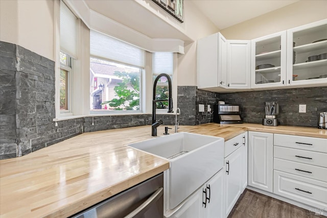 kitchen with sink, backsplash, white cabinetry, dark hardwood / wood-style flooring, and butcher block counters