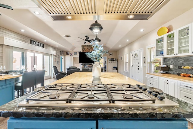 kitchen featuring white cabinetry, stainless steel gas cooktop, light hardwood / wood-style flooring, decorative backsplash, and ceiling fan