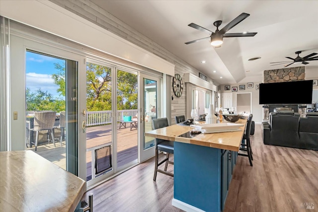 dining room featuring wood-type flooring, vaulted ceiling, and ceiling fan