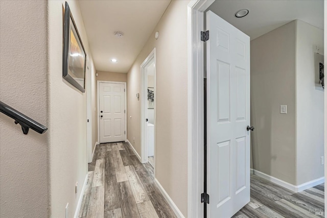 corridor with hardwood / wood-style flooring