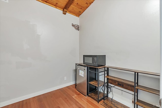 office area featuring hardwood / wood-style flooring, lofted ceiling with beams, and wooden ceiling