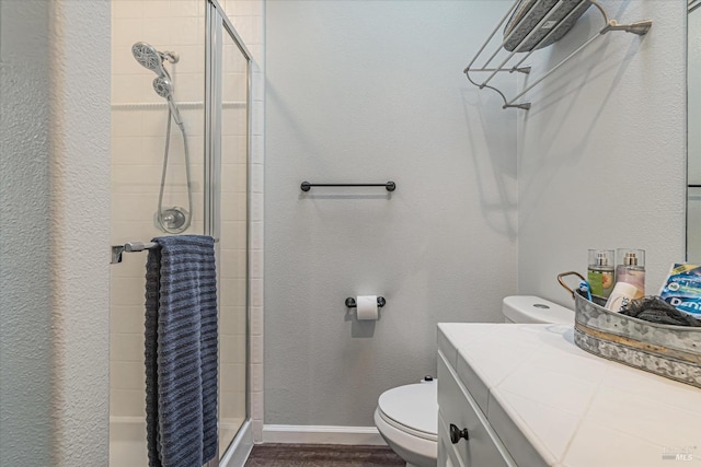 bathroom with walk in shower, vanity, and toilet