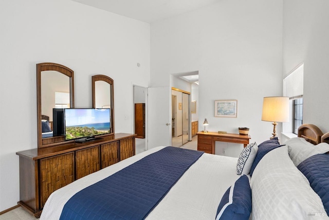 carpeted bedroom with a high ceiling and ensuite bathroom