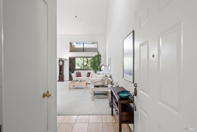 interior space with a towering ceiling and light carpet