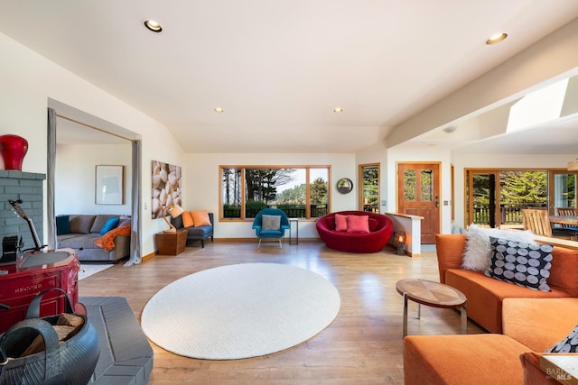 living room featuring lofted ceiling and light hardwood / wood-style floors