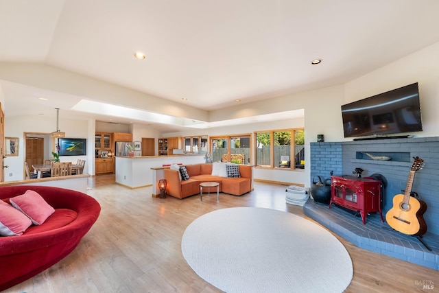 living room with a wood stove and light wood-type flooring