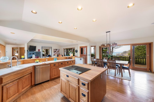 kitchen with dishwasher, lofted ceiling, hanging light fixtures, a center island, and light hardwood / wood-style flooring