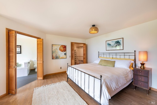 bedroom featuring hardwood / wood-style floors and ensuite bath