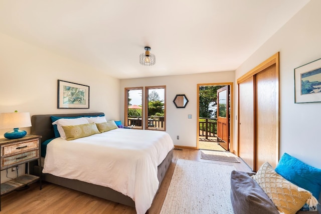 bedroom with a closet, access to exterior, and light hardwood / wood-style flooring