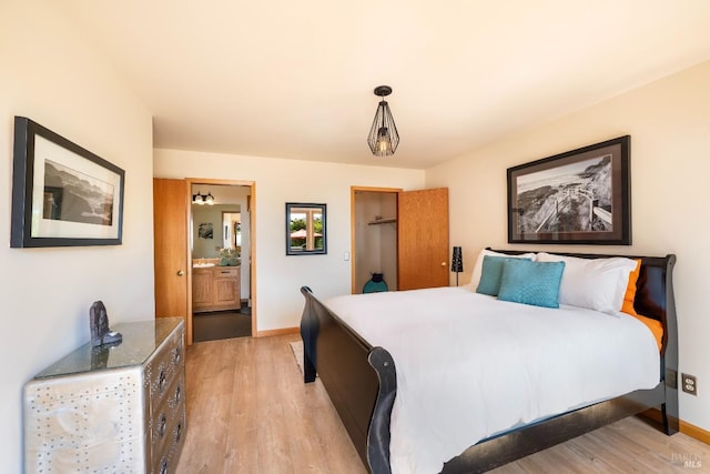 bedroom with connected bathroom and light hardwood / wood-style flooring