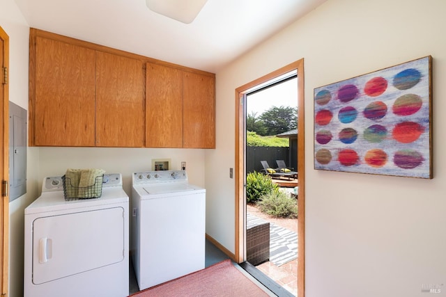 laundry room featuring cabinets, washing machine and clothes dryer, and electric panel