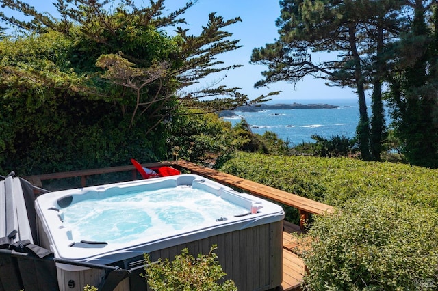 exterior space with a hot tub and a water view