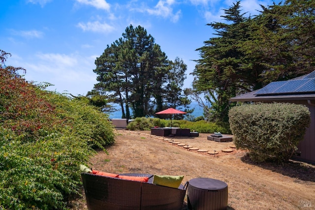 view of yard featuring an outdoor living space with a fire pit