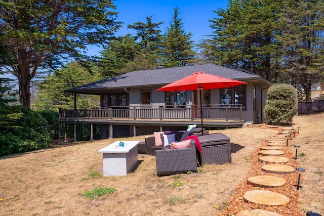 rear view of house with a yard, outdoor lounge area, and a deck