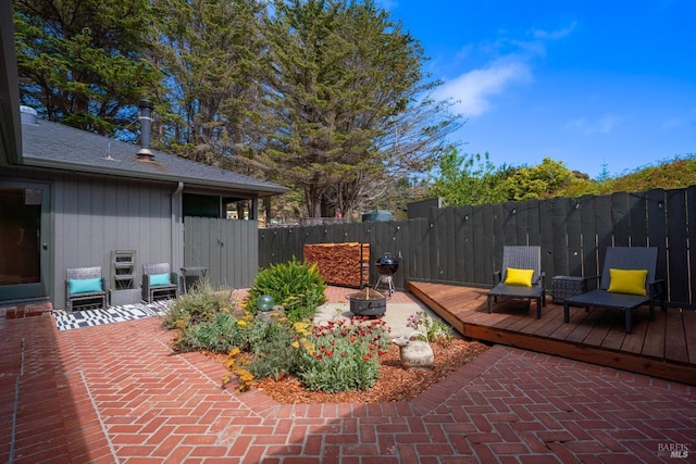 view of patio with a wooden deck and a fire pit