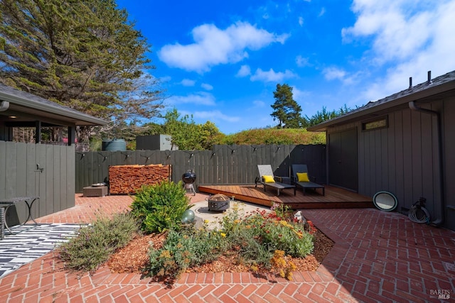 view of patio / terrace featuring a wooden deck and an outdoor fire pit