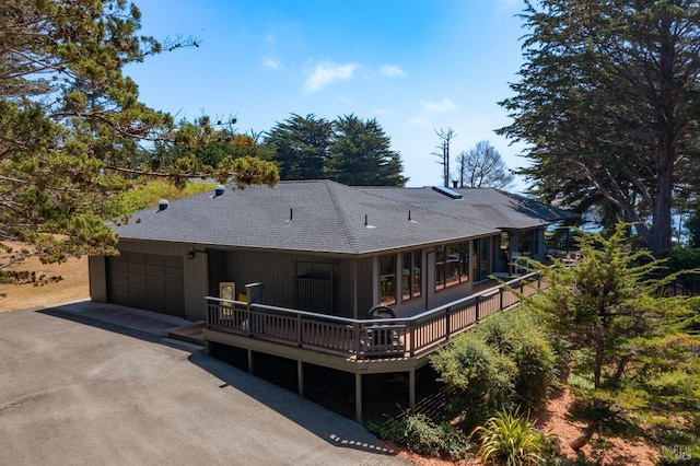 back of house featuring a garage and a deck