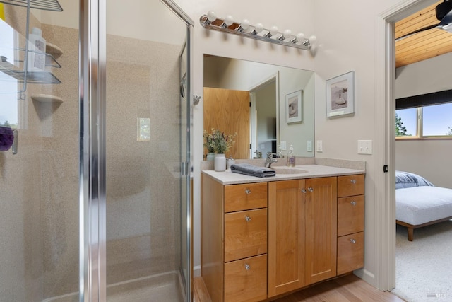 bathroom featuring walk in shower, vanity, and hardwood / wood-style flooring