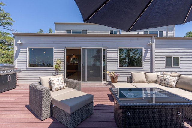 wooden terrace with a grill and an outdoor hangout area