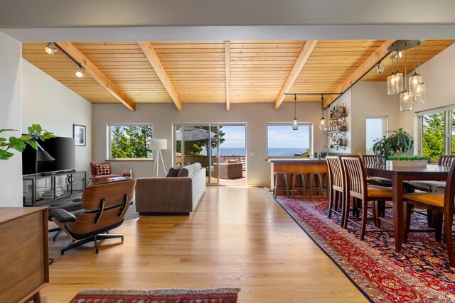 dining space featuring wood ceiling, track lighting, light hardwood / wood-style floors, an inviting chandelier, and vaulted ceiling with beams