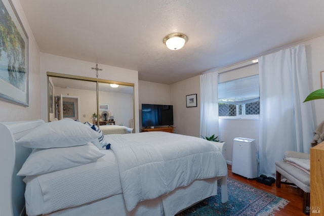 bedroom featuring dark hardwood / wood-style floors, a textured ceiling, and a closet