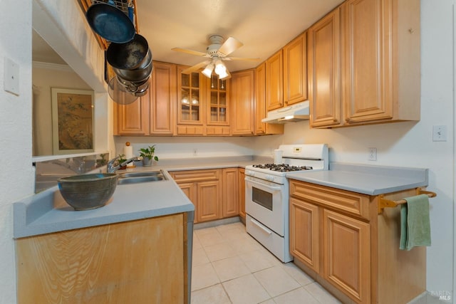 kitchen with white gas range, sink, ceiling fan, light tile patterned floors, and crown molding