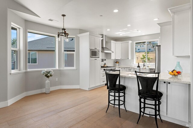 kitchen with light stone countertops, white cabinets, and a healthy amount of sunlight