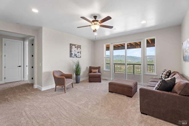 living room featuring a mountain view, ceiling fan, and light carpet