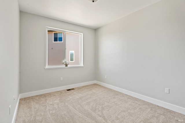 unfurnished room featuring light colored carpet