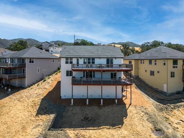 rear view of house featuring a deck with mountain view