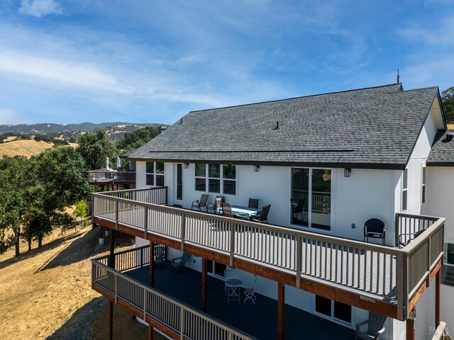 rear view of house featuring an outdoor living space and a deck