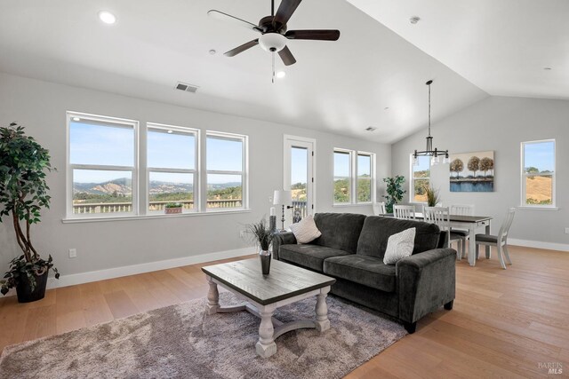 living room featuring light hardwood / wood-style floors, ceiling fan, and lofted ceiling