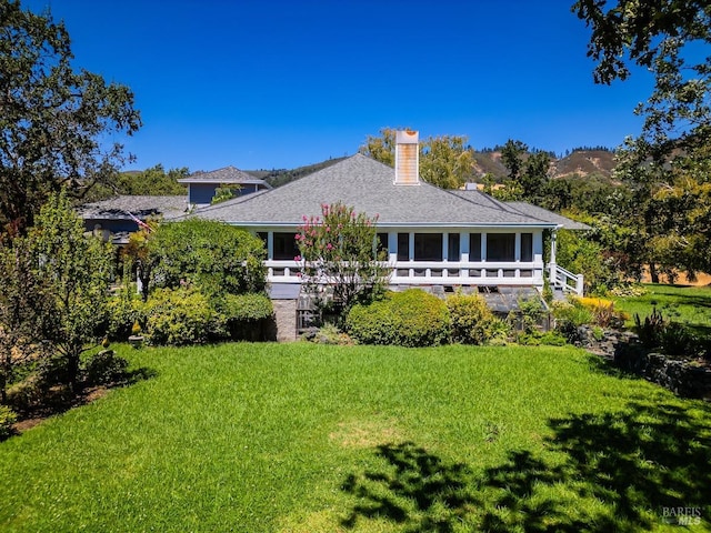 rear view of property featuring a yard