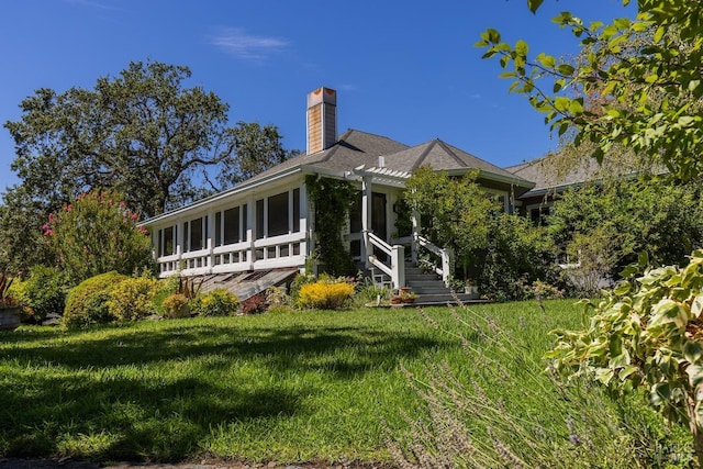 rear view of property with a yard