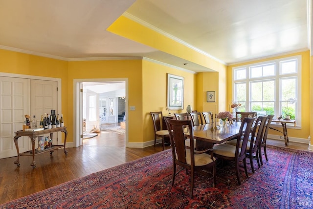 dining space with wood-type flooring and crown molding