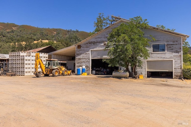 view of home's exterior with a garage, a carport, and a mountain view