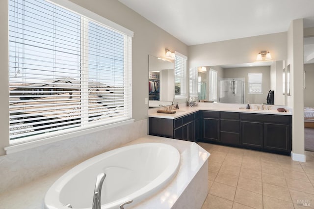 bathroom with tile patterned floors, double vanity, and a relaxing tiled tub