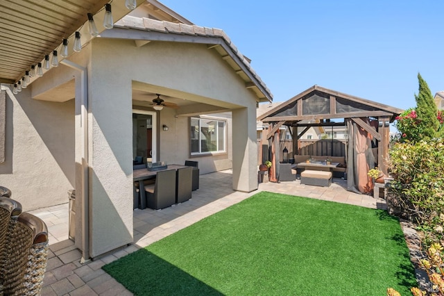 view of yard featuring ceiling fan, a patio area, an outdoor hangout area, and a gazebo