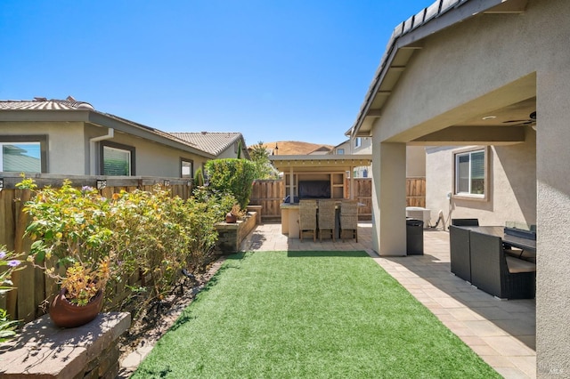 view of yard with ceiling fan, a patio, and an outdoor living space