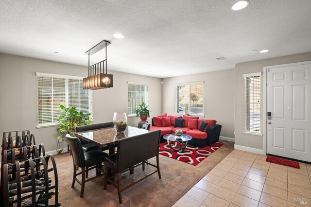 dining space with a textured ceiling and light tile patterned floors