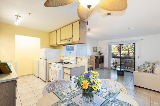 kitchen featuring washer / dryer, white appliances, ceiling fan, and light tile patterned flooring