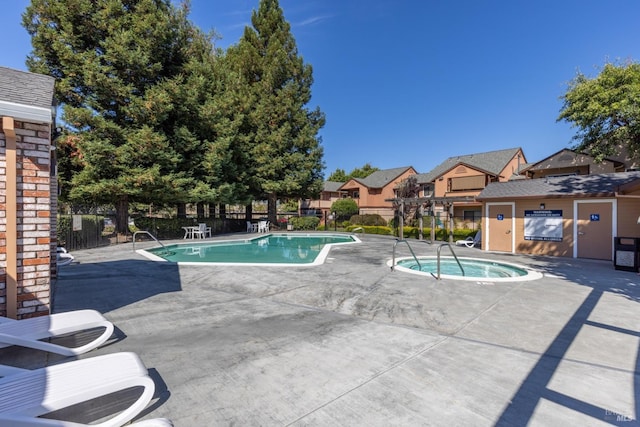 view of swimming pool featuring a patio area and a hot tub